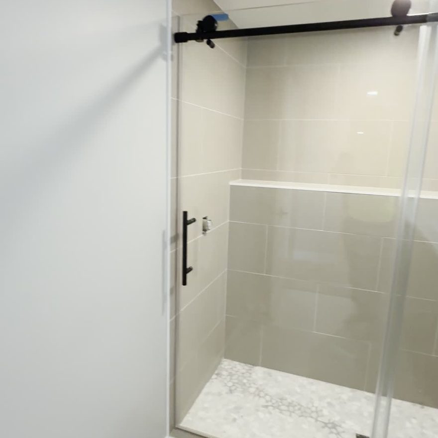 Tile shower with glass panel by Lynnwood Construction